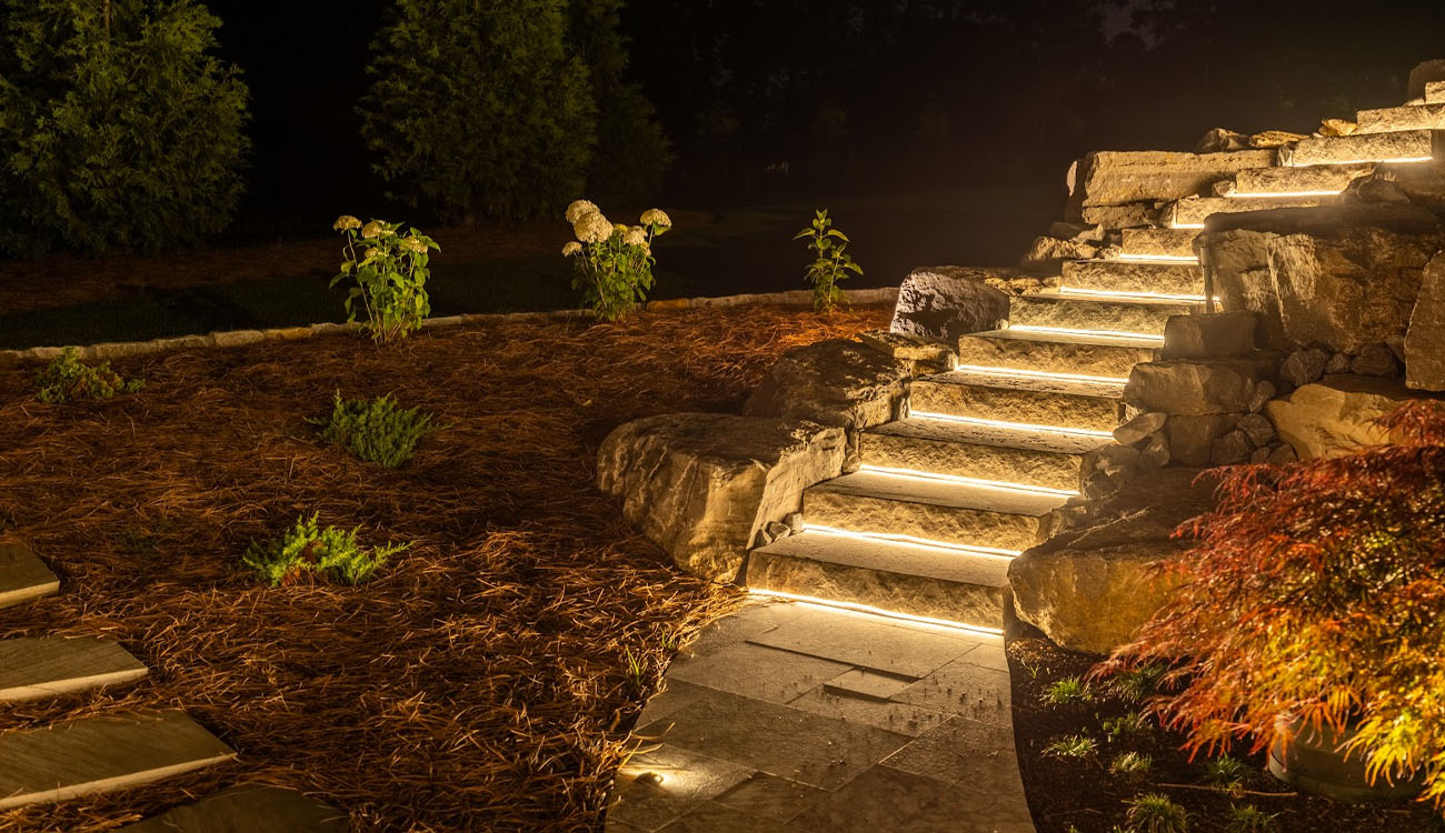 Illuminated stone steps through a landscaped garden