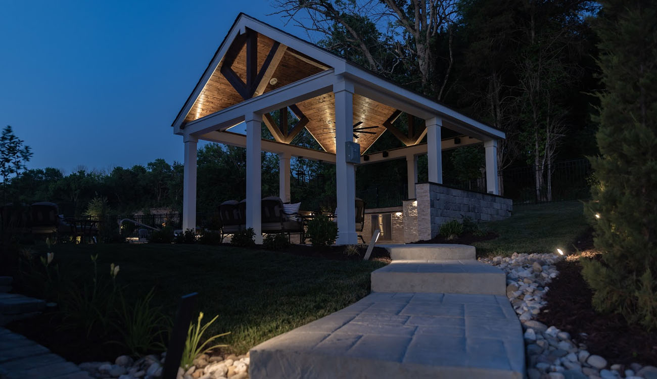 Timber pavilion and garden path illuminated at dusk