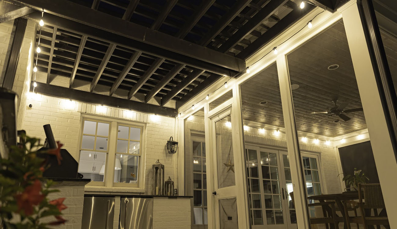 String lights above a covered porch seating area