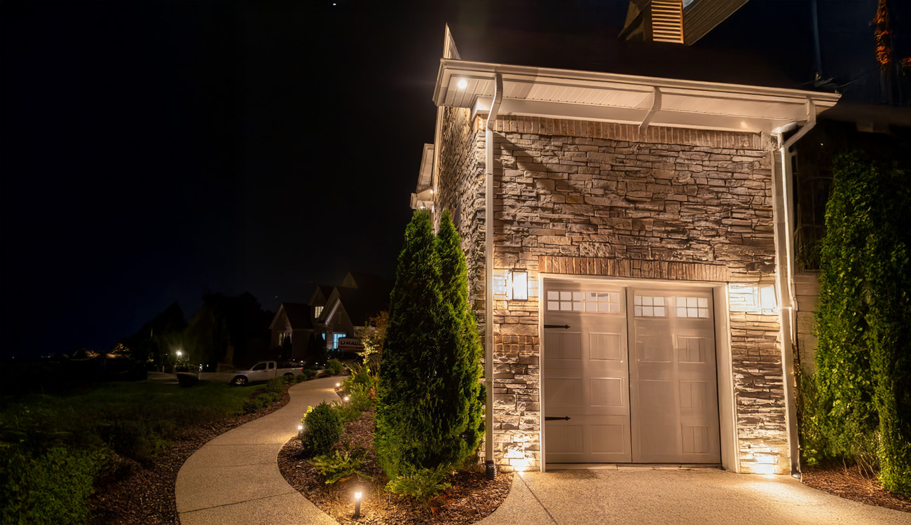 Uplighting highlighting a stone entrance and winding path