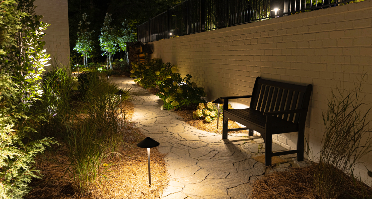 Path lights along a garden walkway beside a bench