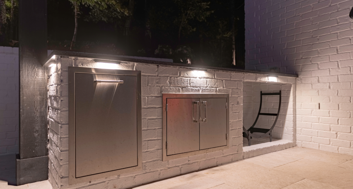 Task lights illuminating an outdoor kitchen counter