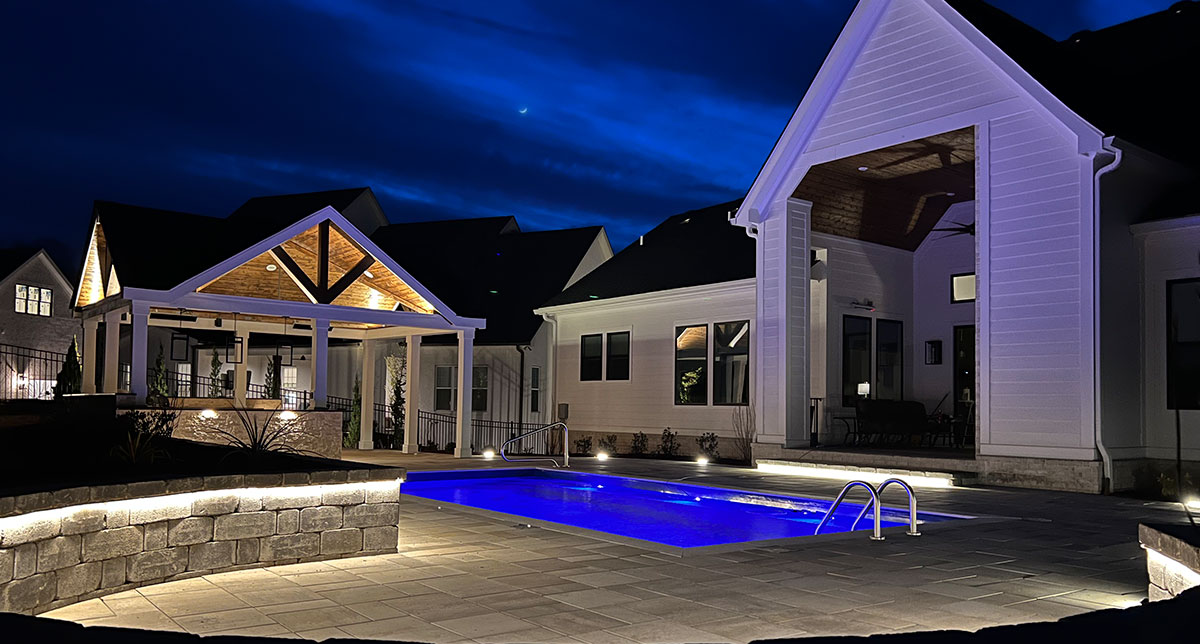 Poolside lighting around a pavilion and outdoor living space