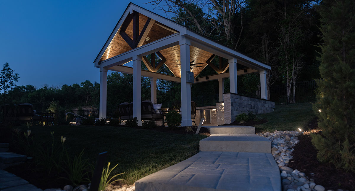 Illuminated timber pavilion at the end of a garden path