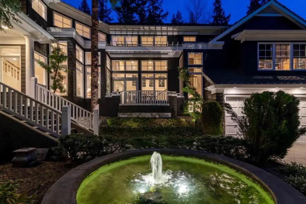 Exterior lighting highlighting a home's stone walls and garden