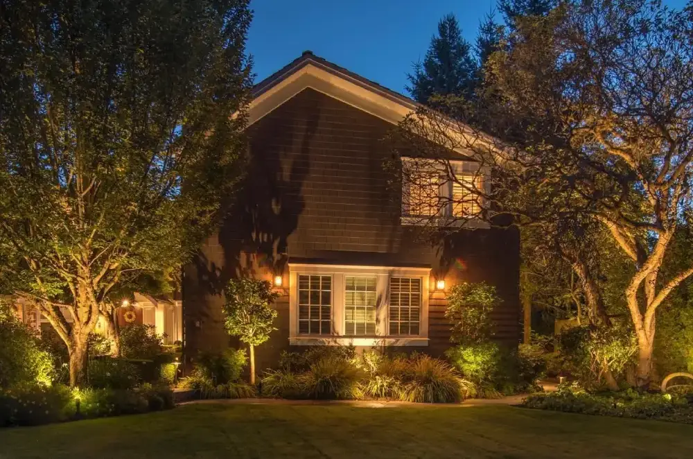 brown house with exterior lighting and trees